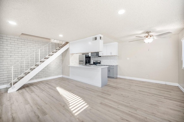 kitchen featuring light hardwood / wood-style floors, stainless steel appliances, kitchen peninsula, decorative backsplash, and white cabinets