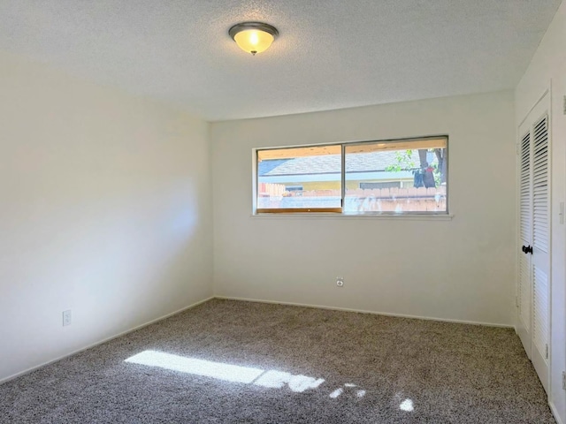 carpeted spare room with a textured ceiling