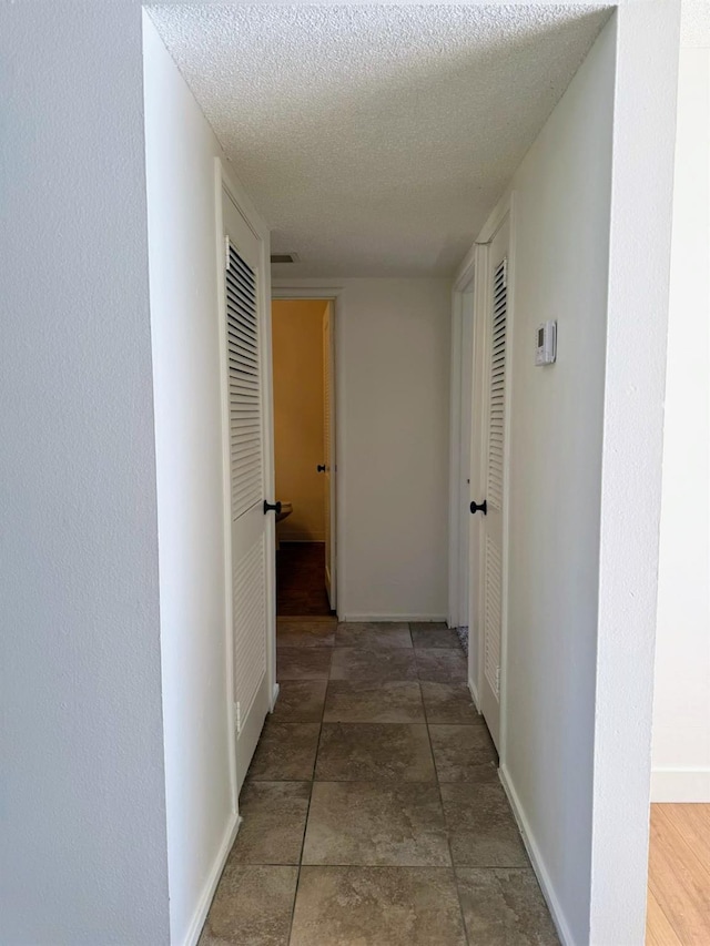 corridor featuring a textured ceiling