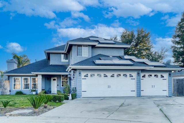 front of property featuring solar panels, a front yard, and a garage