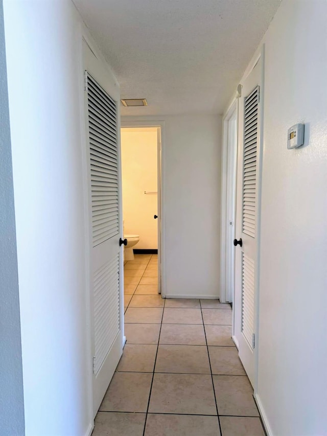 hall featuring light tile patterned floors