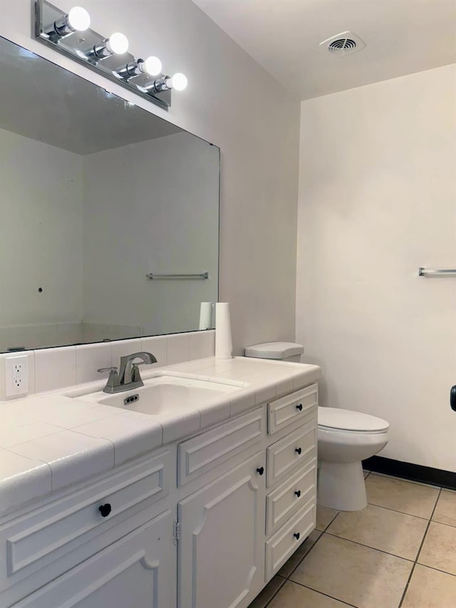 bathroom with vanity, tile patterned floors, and toilet