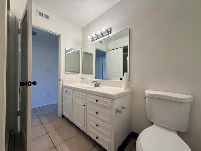 bathroom with toilet, tile patterned flooring, and vanity