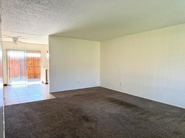 spare room with a textured ceiling, ceiling fan, and light colored carpet