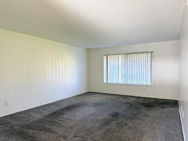 carpeted spare room with a textured ceiling