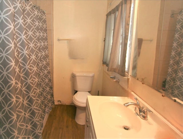 bathroom with toilet, hardwood / wood-style flooring, and vanity