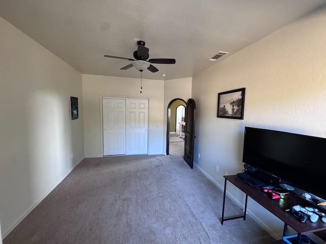 unfurnished bedroom featuring ceiling fan, a closet, and carpet