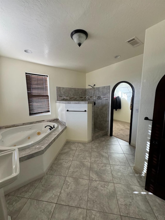 bathroom featuring tile patterned flooring, a textured ceiling, and separate shower and tub