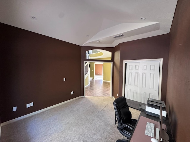 carpeted office space featuring lofted ceiling