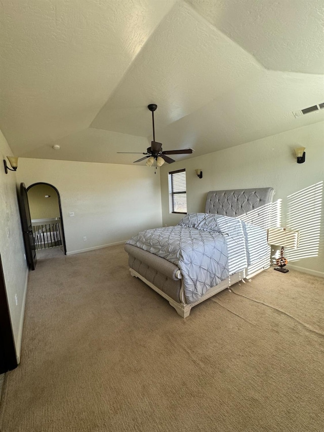 carpeted bedroom with ceiling fan, lofted ceiling, and a textured ceiling