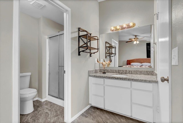 bathroom featuring ceiling fan, vanity, a shower with shower door, and toilet