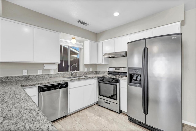 kitchen with stainless steel appliances, white cabinets, sink, and light stone countertops