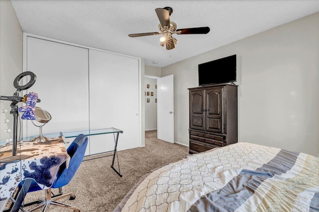 bedroom with ceiling fan, a closet, carpet floors, and a textured ceiling