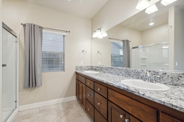 bathroom with a shower with door, tile patterned floors, and vanity