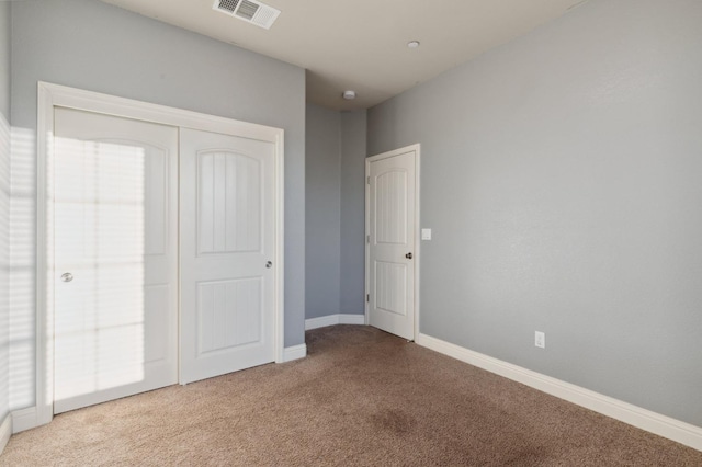 unfurnished bedroom featuring light colored carpet and a closet