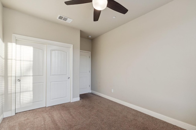 unfurnished bedroom featuring ceiling fan, a closet, and carpet