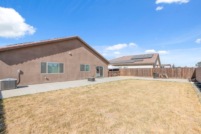 back of property with a patio area, central AC unit, and a lawn