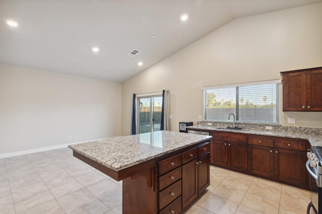 kitchen with sink, a kitchen breakfast bar, a center island, and light tile patterned floors