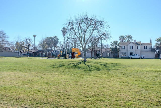 view of property's community with a playground and a yard