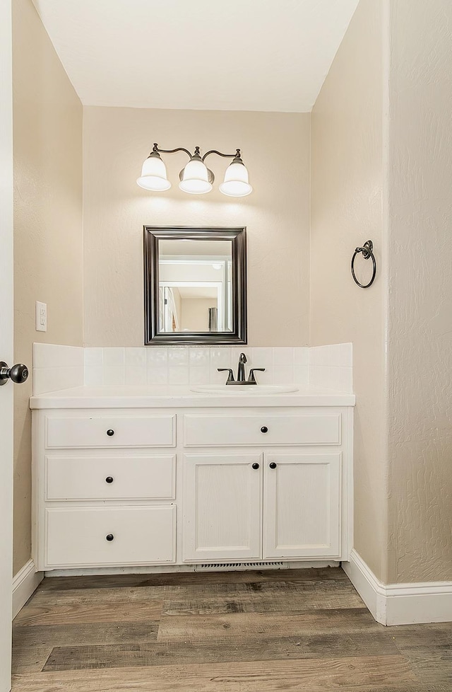 bathroom with vanity, baseboards, and wood finished floors