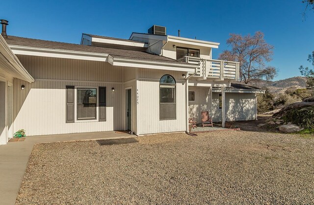 rear view of house featuring central AC unit and a balcony