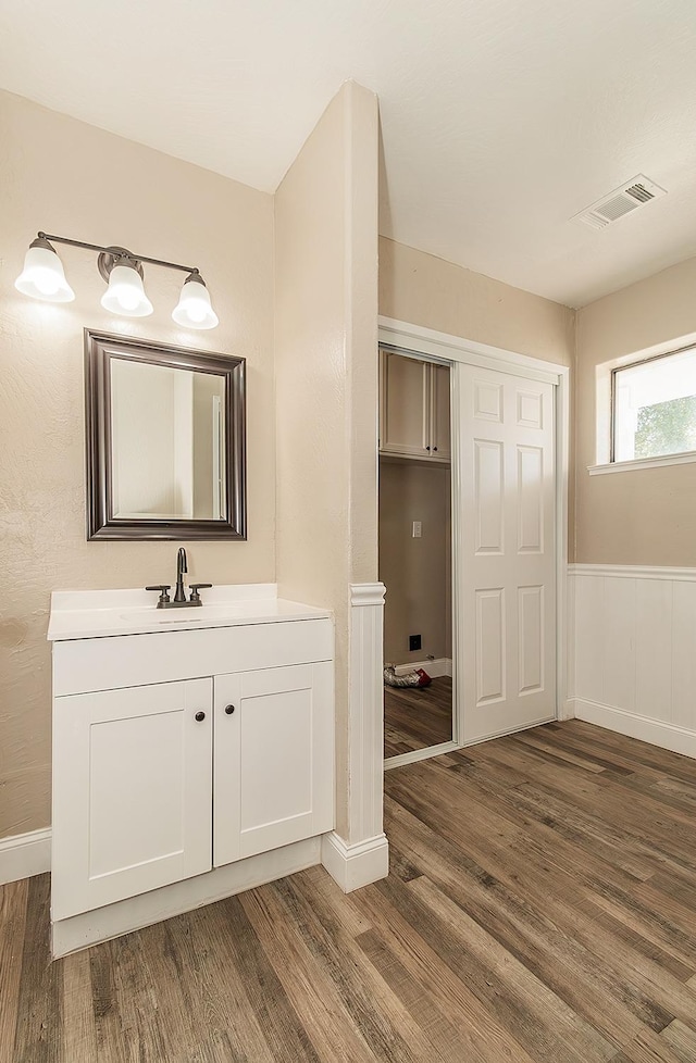 bathroom featuring wainscoting, visible vents, vanity, and wood finished floors