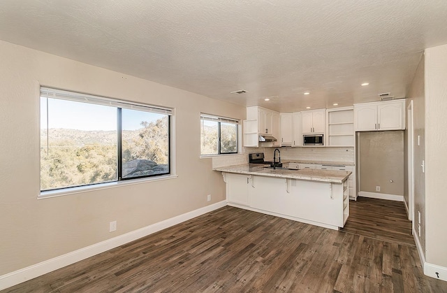 kitchen featuring dark wood-style floors, open shelves, stainless steel appliances, white cabinetry, and a peninsula