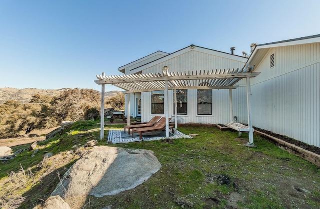 rear view of house with a yard, a patio area, and a pergola