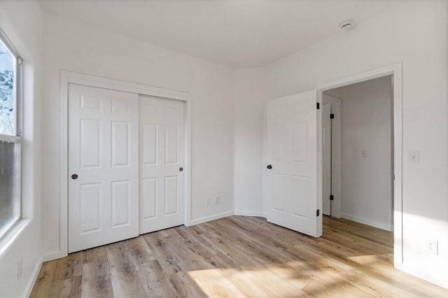 unfurnished bedroom featuring a closet and light wood-type flooring