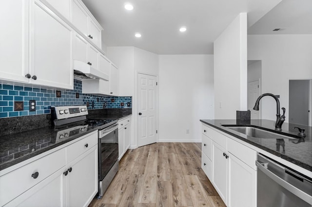 kitchen with white cabinets, sink, appliances with stainless steel finishes, and dark stone countertops