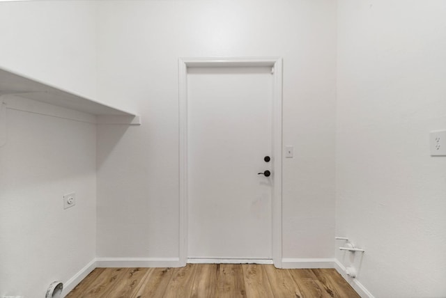 washroom with hardwood / wood-style flooring and electric dryer hookup