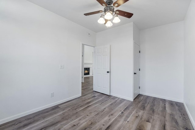 spare room with ceiling fan and light wood-type flooring