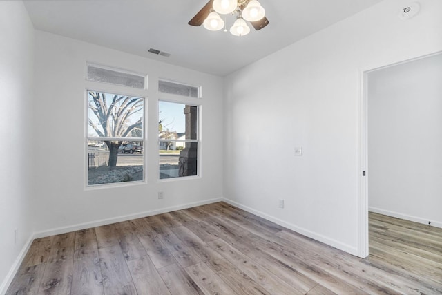 empty room with ceiling fan and light hardwood / wood-style flooring