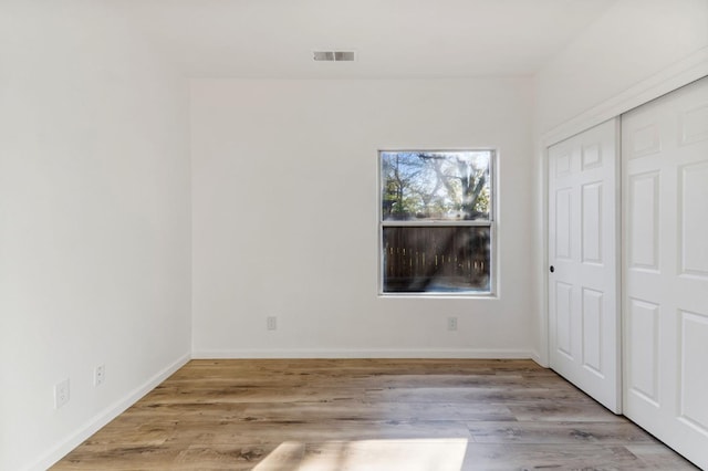 unfurnished bedroom featuring a closet and light hardwood / wood-style floors