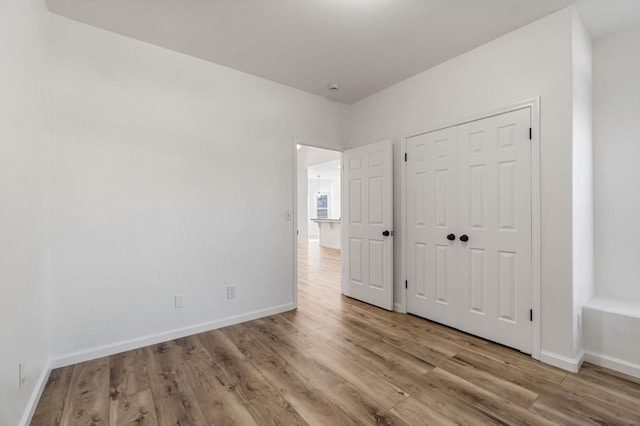 unfurnished bedroom with a closet and light wood-type flooring