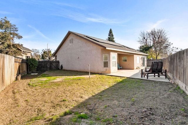 back of house with a patio area and a yard