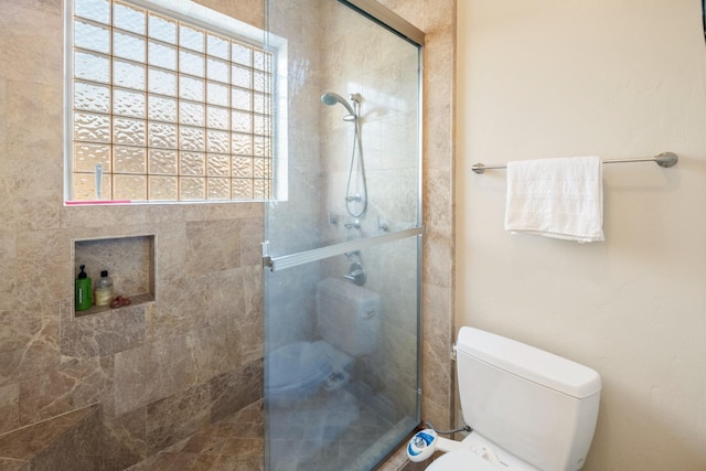 bathroom with toilet and a tile shower