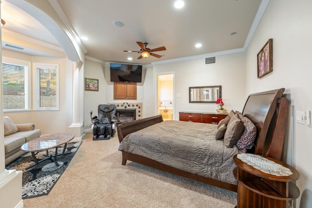 bedroom featuring ceiling fan, crown molding, light carpet, and a fireplace