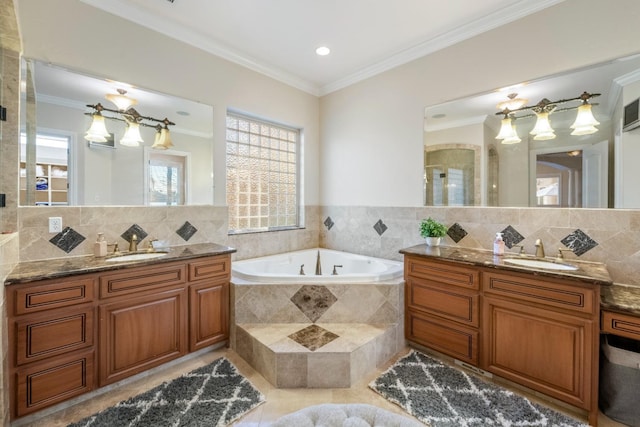 bathroom with tiled tub, vanity, and ornamental molding