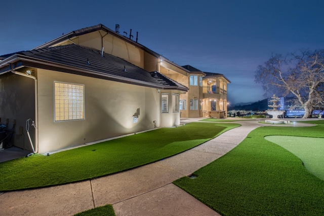 exterior space featuring a balcony and a lawn