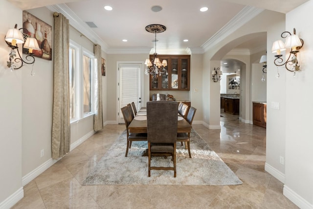 dining room with a notable chandelier, sink, and ornamental molding