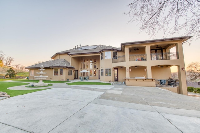 view of front facade featuring ceiling fan, a patio area, and a balcony