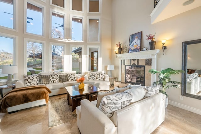 living room with a fireplace, light tile patterned flooring, and a towering ceiling