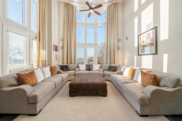 living room featuring ceiling fan and a towering ceiling