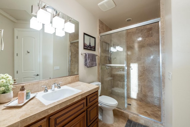 bathroom featuring toilet, vanity, and an enclosed shower