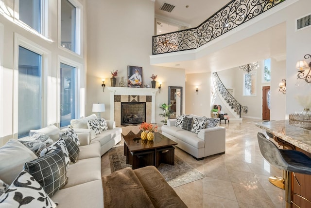 living room featuring a fireplace and a towering ceiling