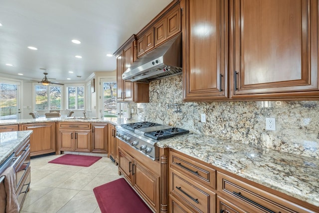 kitchen with stainless steel gas stovetop, ceiling fan, tasteful backsplash, range hood, and sink