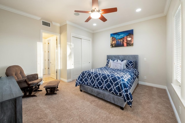 carpeted bedroom featuring ceiling fan, a closet, and crown molding