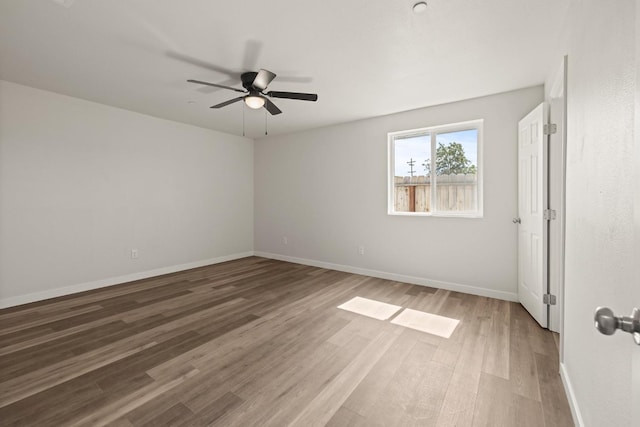 unfurnished room featuring ceiling fan, baseboards, and wood finished floors