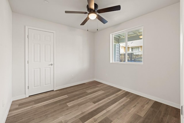 unfurnished room featuring ceiling fan, baseboards, and wood finished floors